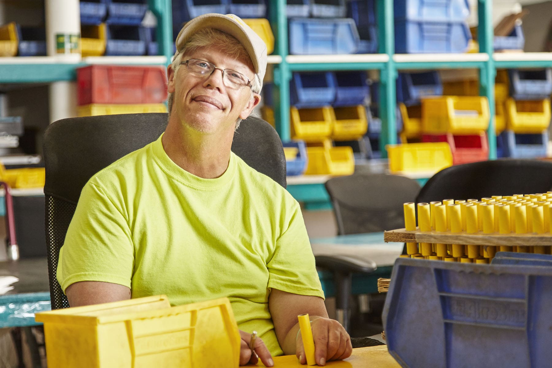 A philanthropic man sitting at a desk in a warehouse.