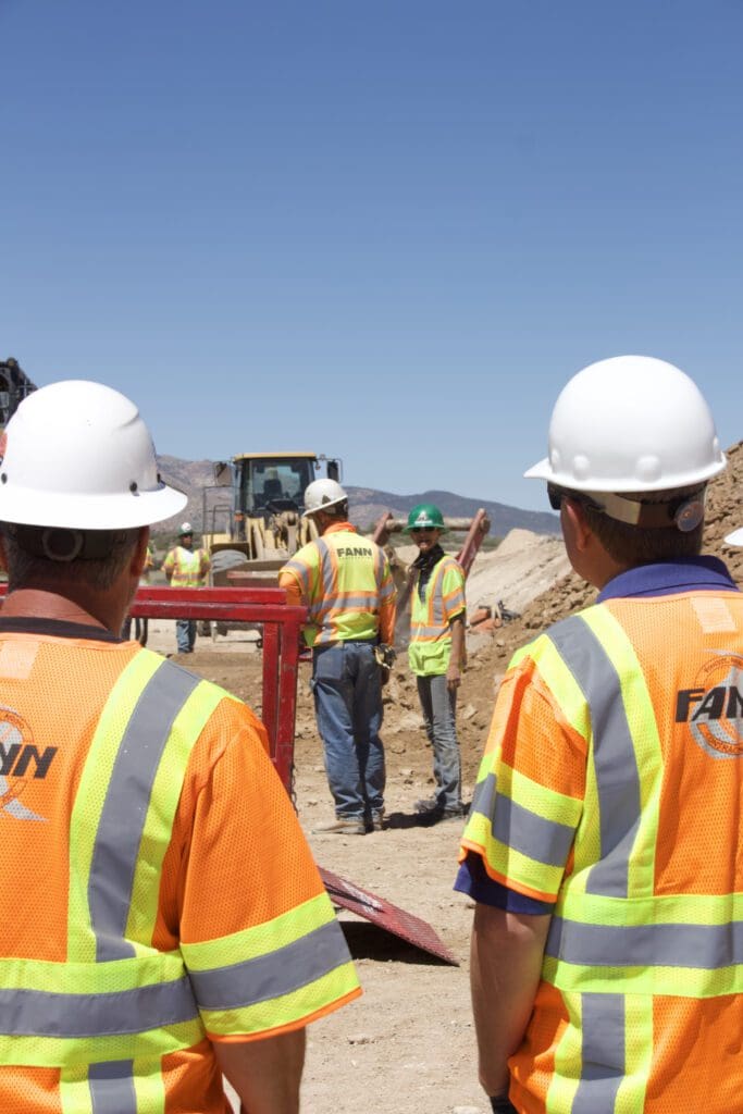 A group of construction workers preparing equipment for winter.